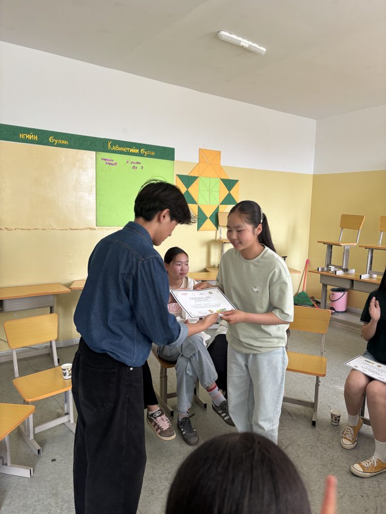 A GRIT EDU student receives a certificate of completion